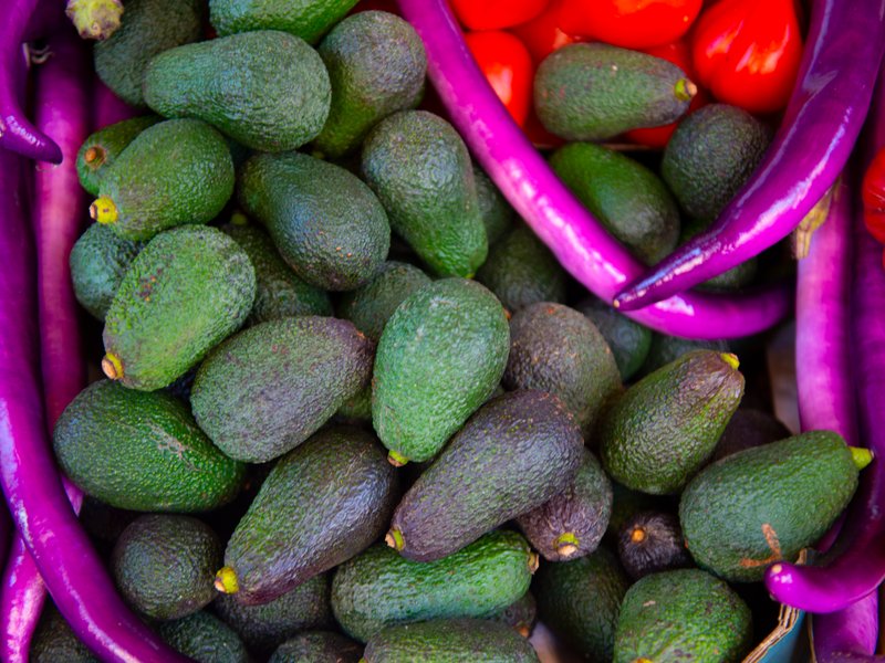 Aguacates frescos junto a berenjenas y tomates